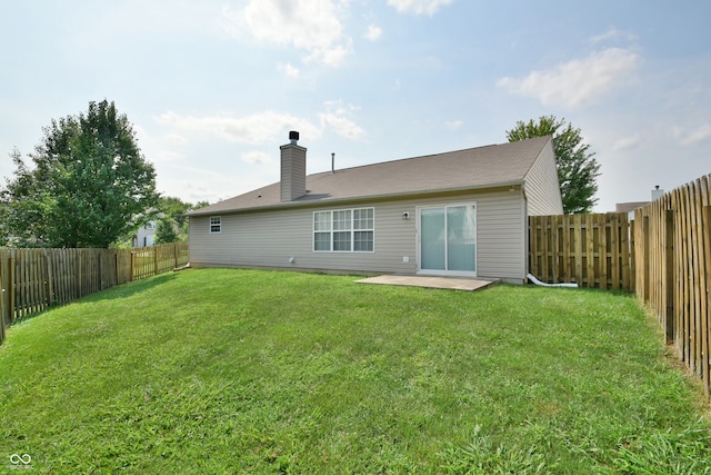 back of house with a patio and a yard