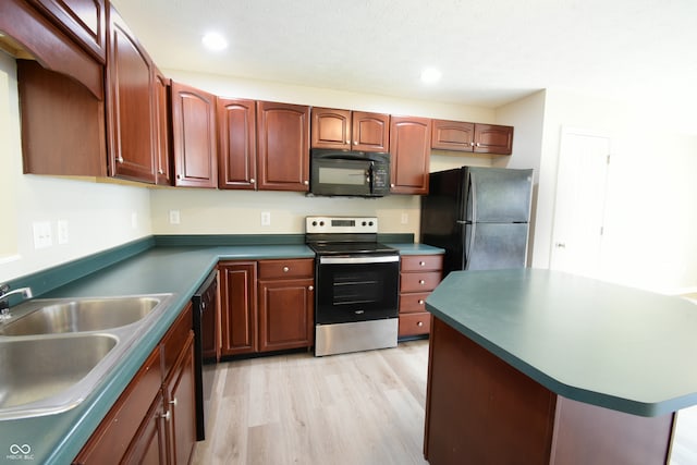 kitchen with black appliances, light hardwood / wood-style flooring, and sink