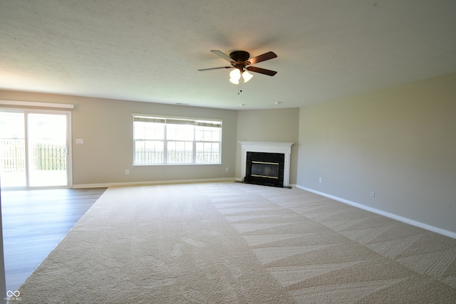 unfurnished living room with ceiling fan, a textured ceiling, and light carpet