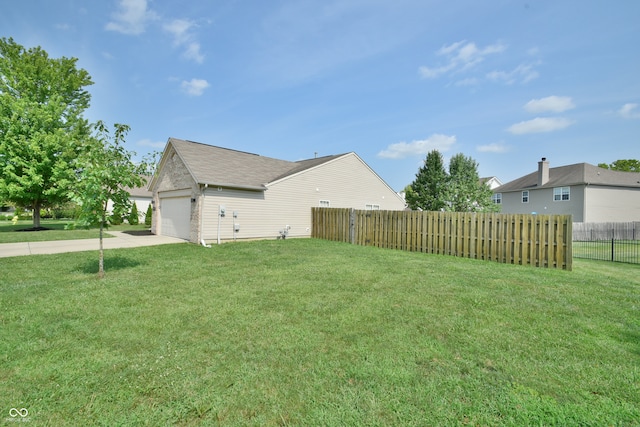 view of side of property with a garage and a lawn