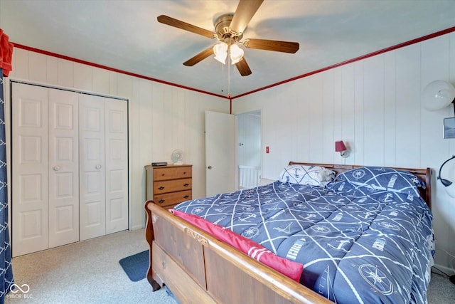 bedroom featuring crown molding, light colored carpet, ceiling fan, and a closet