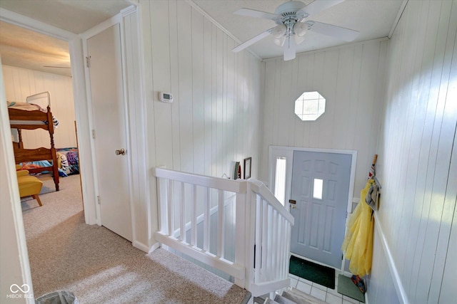 entrance foyer with ornamental molding, light colored carpet, and ceiling fan