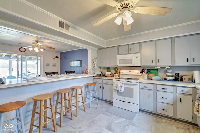 kitchen with crown molding, white appliances, gray cabinets, a breakfast bar, and ceiling fan