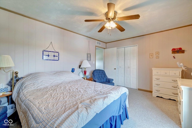 bedroom featuring light carpet, ornamental molding, a closet, and ceiling fan