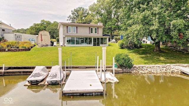 view of dock featuring a lawn and a water view