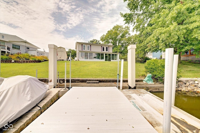 view of dock featuring a water view and a yard