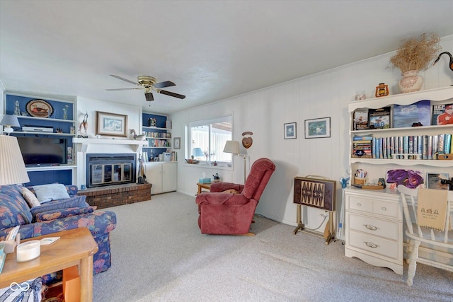 living room with a brick fireplace, carpet, and ceiling fan