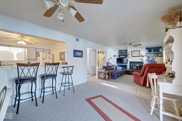 living room with crown molding, light carpet, and ceiling fan