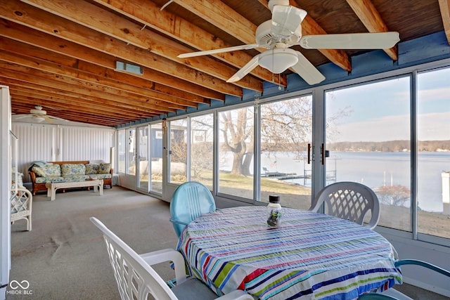 sunroom / solarium featuring a water view, a healthy amount of sunlight, and ceiling fan