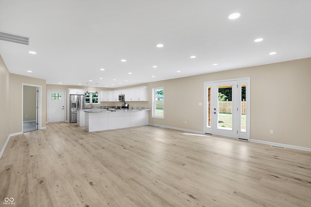 unfurnished living room featuring sink and light wood-type flooring