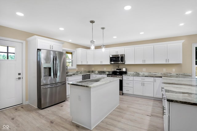 kitchen with appliances with stainless steel finishes, light wood-type flooring, and white cabinetry