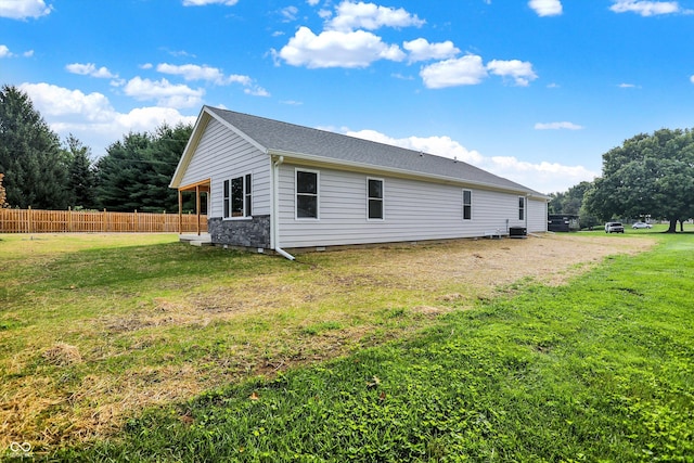 view of side of home featuring cooling unit and a lawn