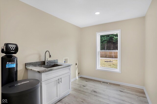 laundry room featuring light wood-type flooring, plenty of natural light, sink, and hookup for an electric dryer