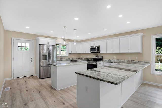 kitchen featuring stainless steel appliances, light hardwood / wood-style flooring, and plenty of natural light