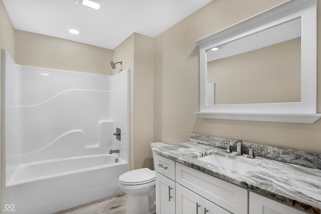 full bathroom with toilet, hardwood / wood-style flooring, vanity, and tub / shower combination