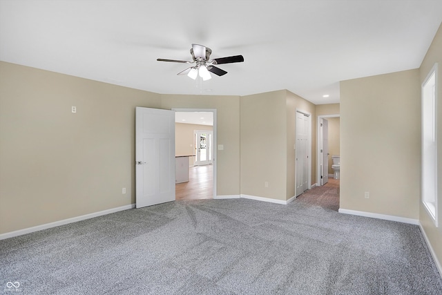 unfurnished bedroom featuring ensuite bathroom, ceiling fan, carpet flooring, and a closet