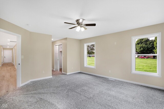 unfurnished room with ceiling fan and light colored carpet