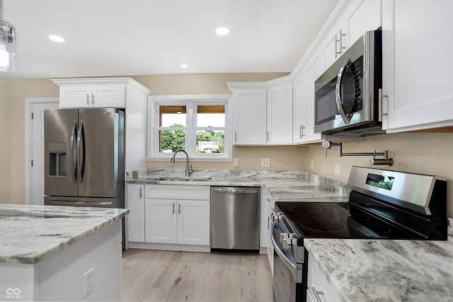 kitchen featuring sink, light wood-type flooring, stainless steel appliances, and white cabinetry