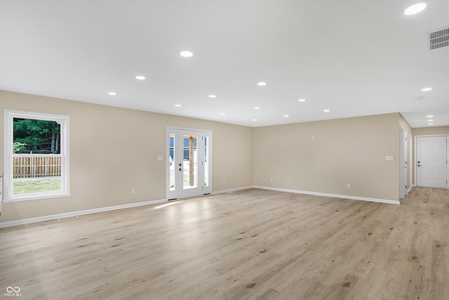 spare room with a wealth of natural light and light wood-type flooring