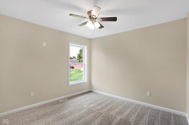 empty room featuring ceiling fan and carpet