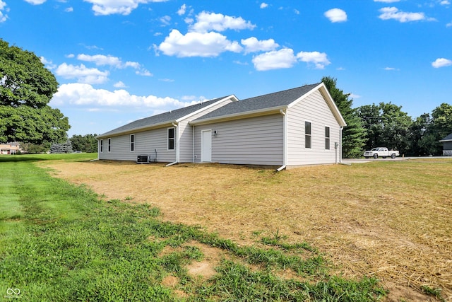 back of property featuring a yard and central air condition unit