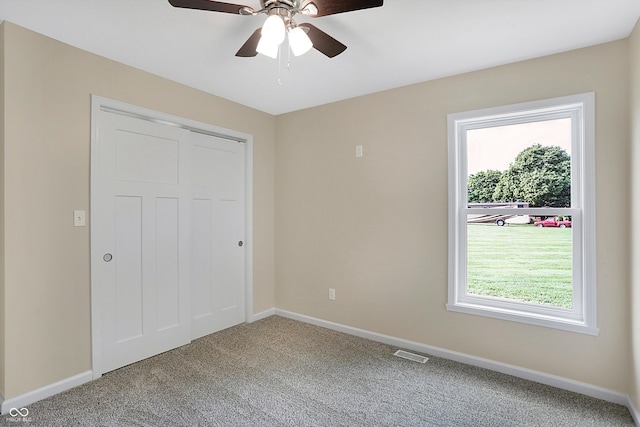 unfurnished bedroom with multiple windows, light carpet, ceiling fan, and a closet