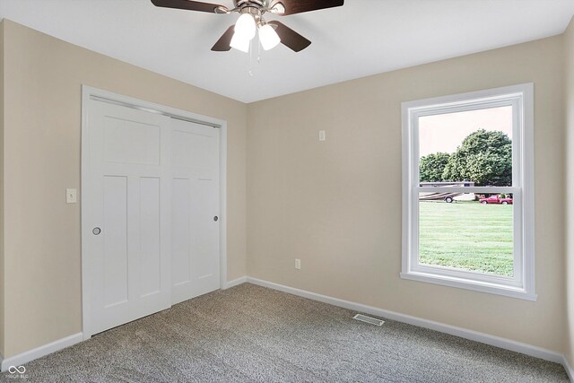 unfurnished bedroom with a closet, ceiling fan, and carpet flooring