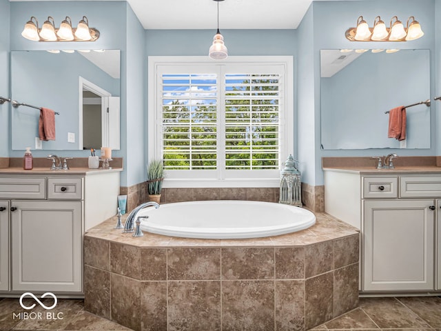 bathroom featuring a relaxing tiled tub, vanity, and tile patterned floors