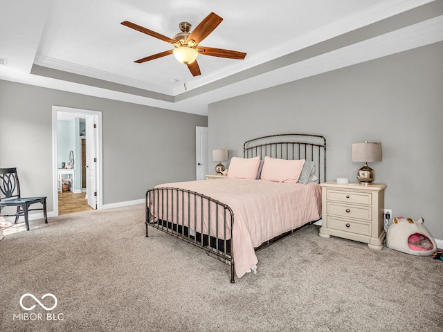 carpeted bedroom featuring ceiling fan, a raised ceiling, and ornamental molding