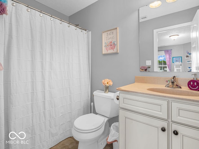 bathroom featuring vanity, tile patterned floors, and toilet