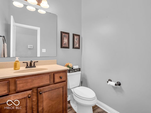 bathroom featuring vanity, toilet, and hardwood / wood-style flooring