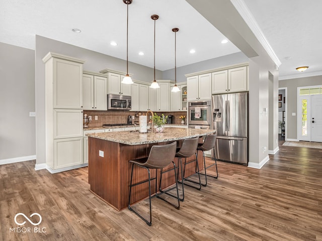 kitchen with pendant lighting, wood-type flooring, tasteful backsplash, and stainless steel appliances