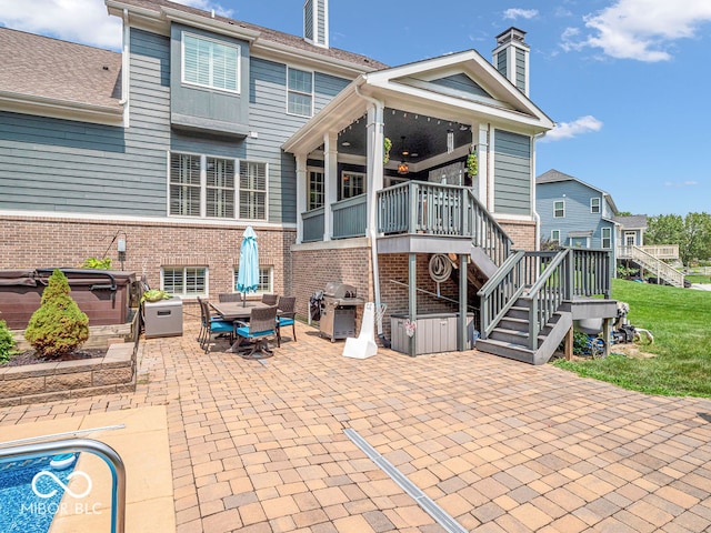 back of house with a patio area and a hot tub