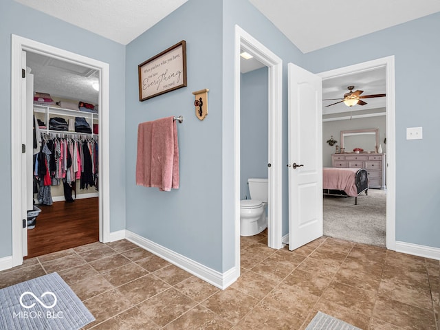 bathroom with tile patterned flooring, a textured ceiling, toilet, and ceiling fan