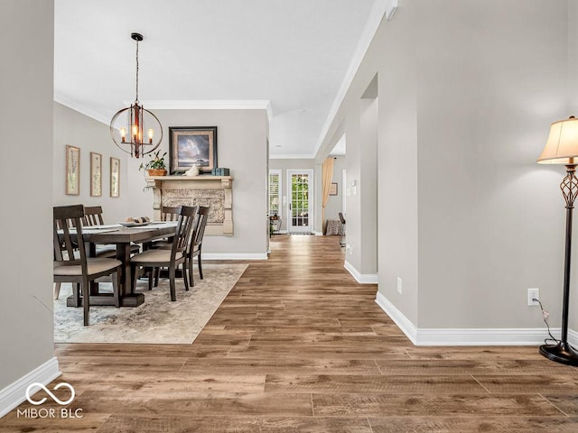 dining area with hardwood / wood-style flooring, a notable chandelier, and crown molding