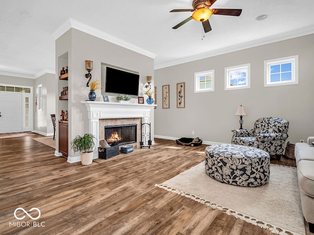 living room with ornamental molding, a fireplace, and hardwood / wood-style flooring