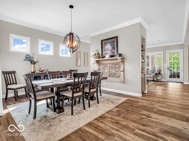 dining area featuring a notable chandelier, wood-type flooring, and crown molding