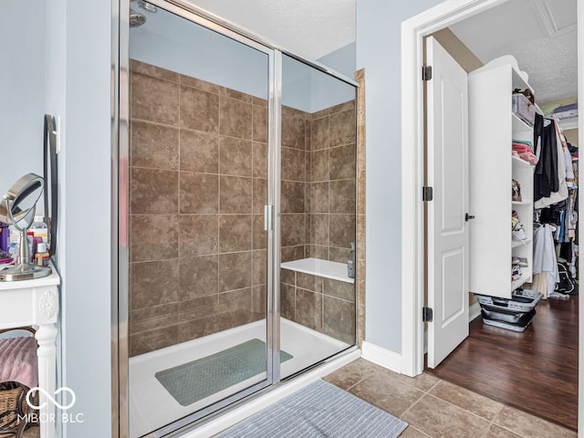 bathroom featuring walk in shower, a textured ceiling, and tile patterned floors