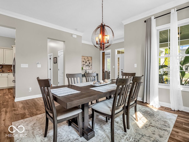 dining area with an inviting chandelier, crown molding, and hardwood / wood-style flooring