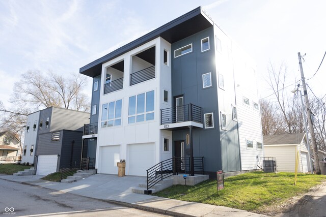 modern home featuring a balcony, a garage, central AC, and a front yard