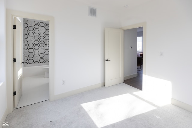 unfurnished bedroom featuring connected bathroom and carpet