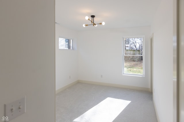 spare room with light carpet and an inviting chandelier