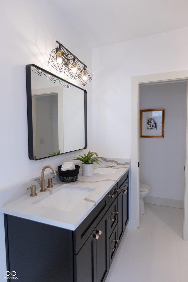 bathroom featuring toilet, tile patterned floors, and double sink vanity