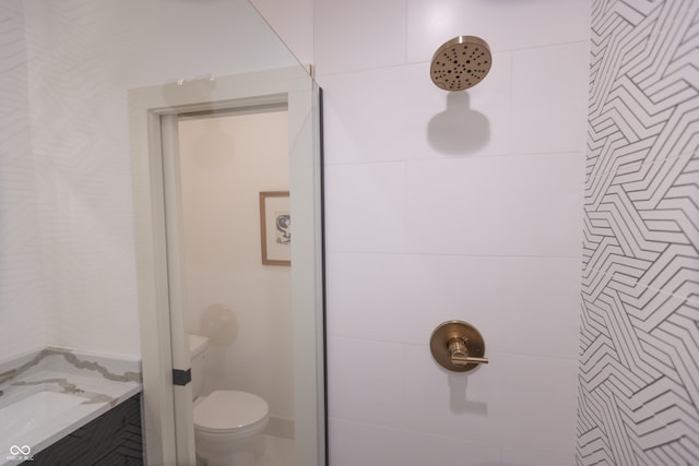 bathroom featuring a shower, vanity, and toilet