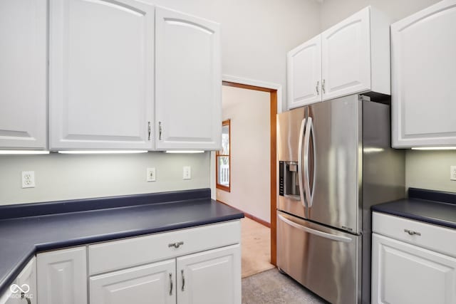 kitchen with white cabinetry and stainless steel fridge