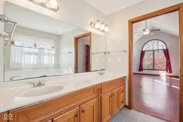 bathroom with vanity, ceiling fan, and vaulted ceiling