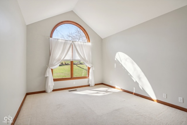 carpeted empty room featuring vaulted ceiling