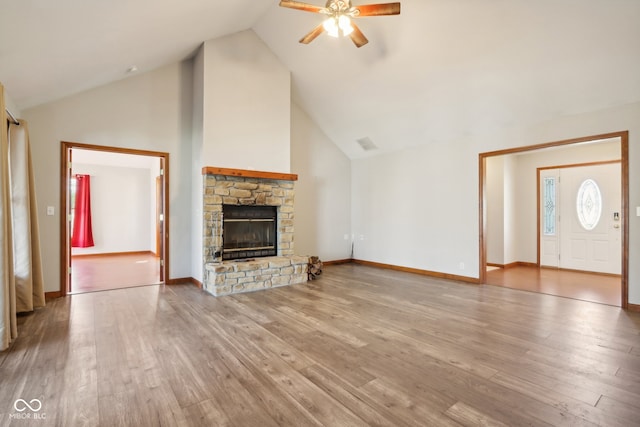 unfurnished living room featuring a fireplace, light hardwood / wood-style floors, ceiling fan, and high vaulted ceiling