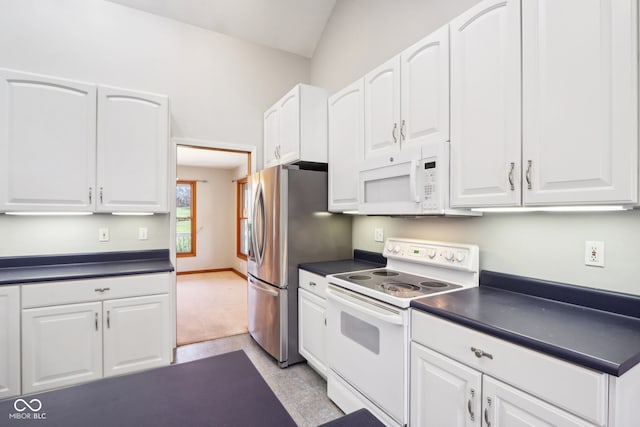 kitchen with white cabinets, lofted ceiling, light carpet, and white appliances