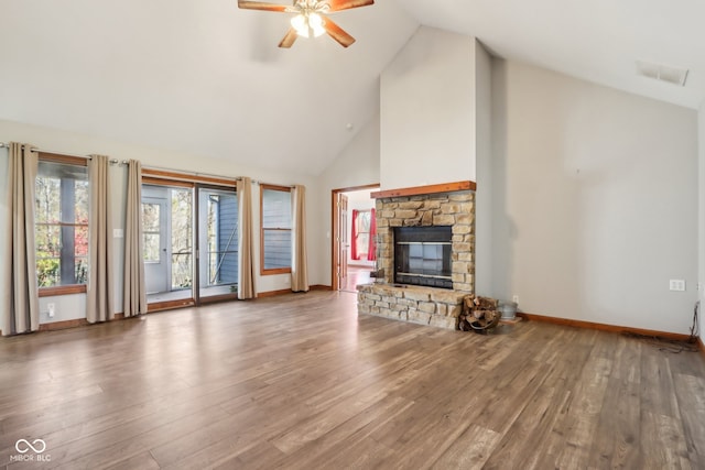 unfurnished living room with dark wood-type flooring, high vaulted ceiling, ceiling fan, and a stone fireplace